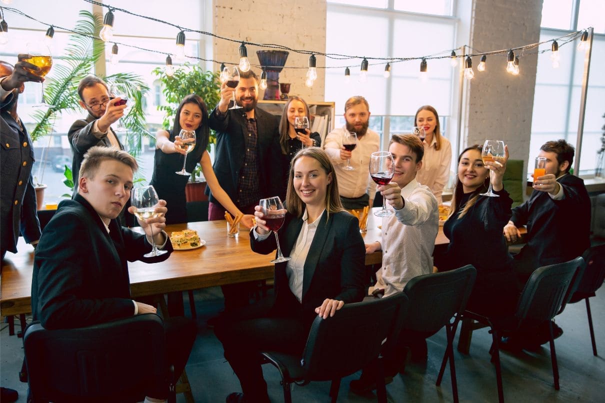 A group of professionals in formal attire raising their glasses in a celebratory toast.